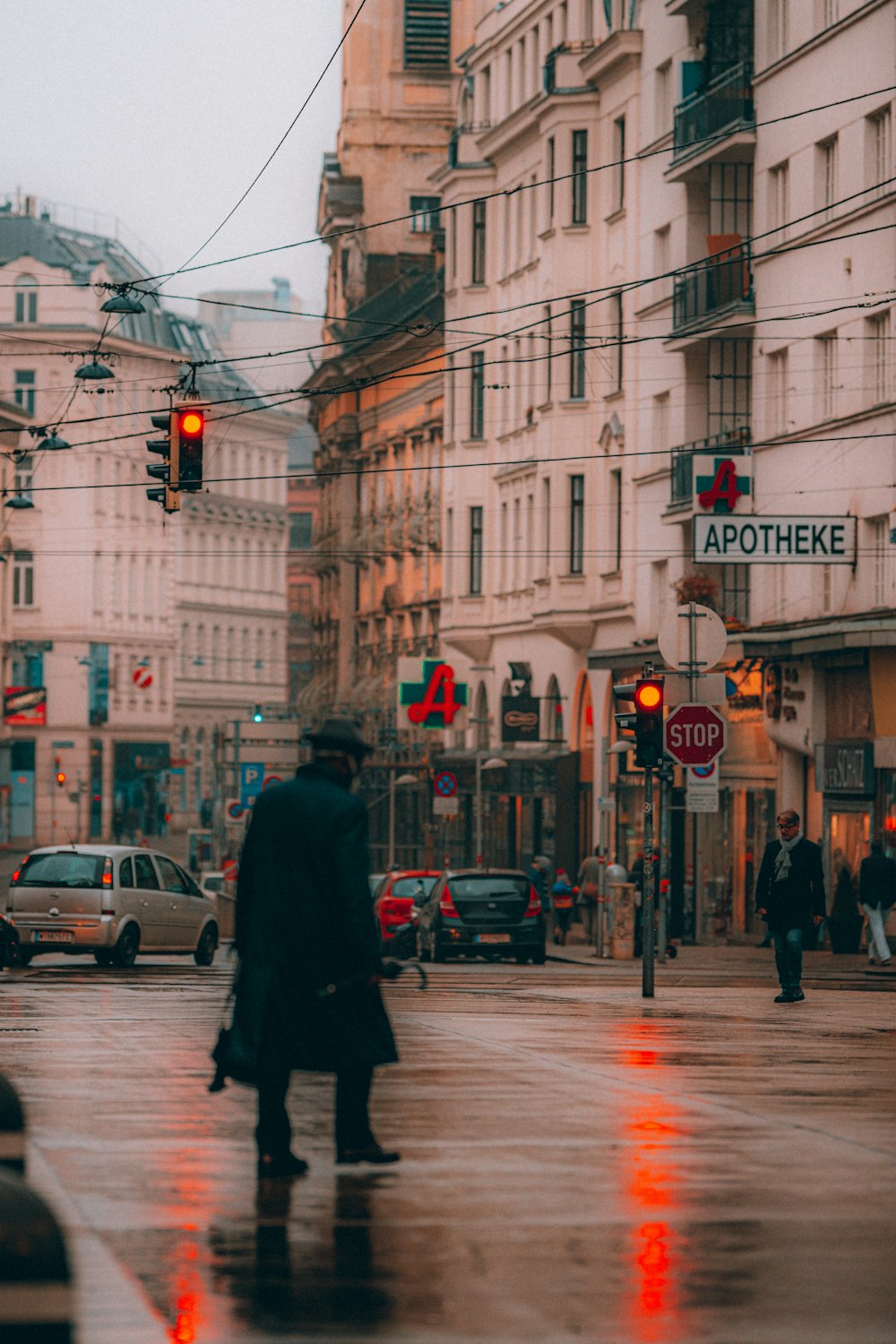 man in black coat standing on sidewalk during daytime