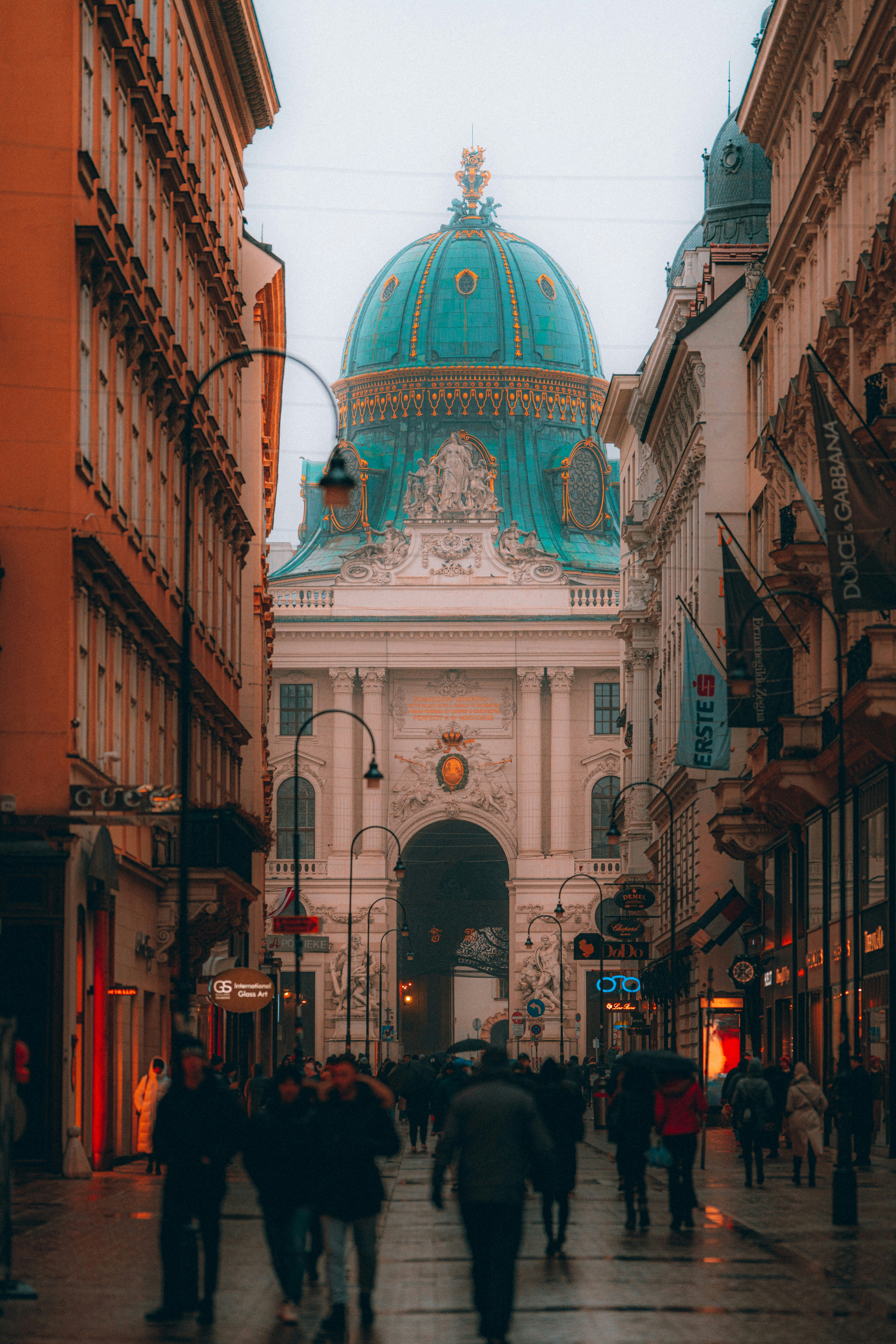 Menschen, die tagsüber auf der Straße in der Nähe des braunen Betongebäudes spazieren gehen