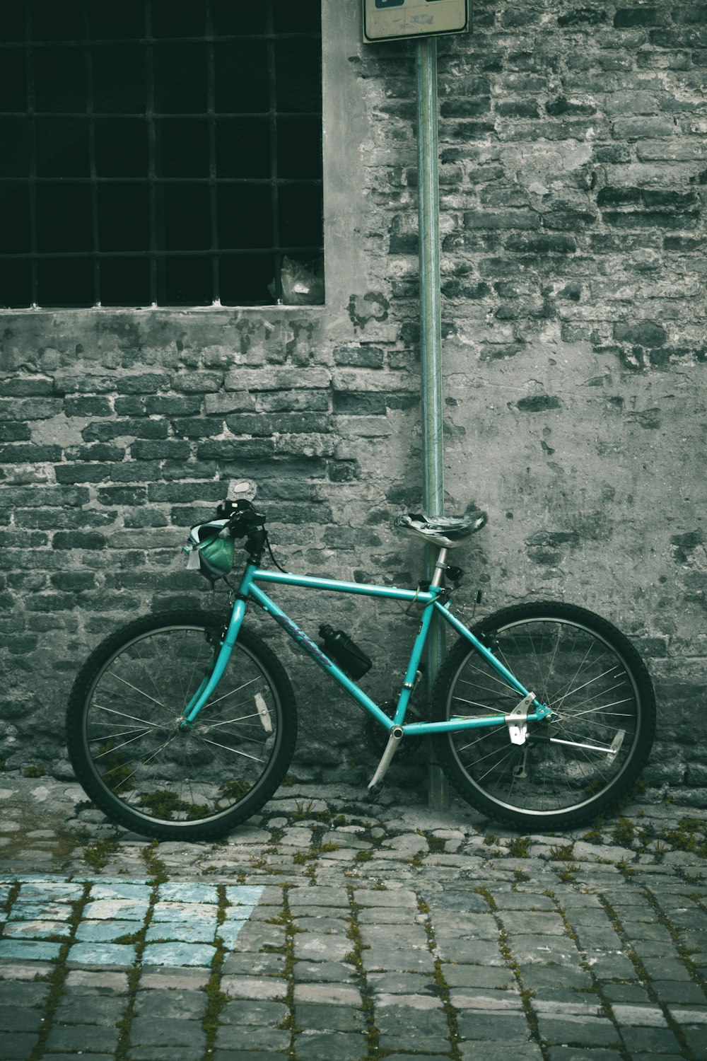 black and green road bike leaning on wall