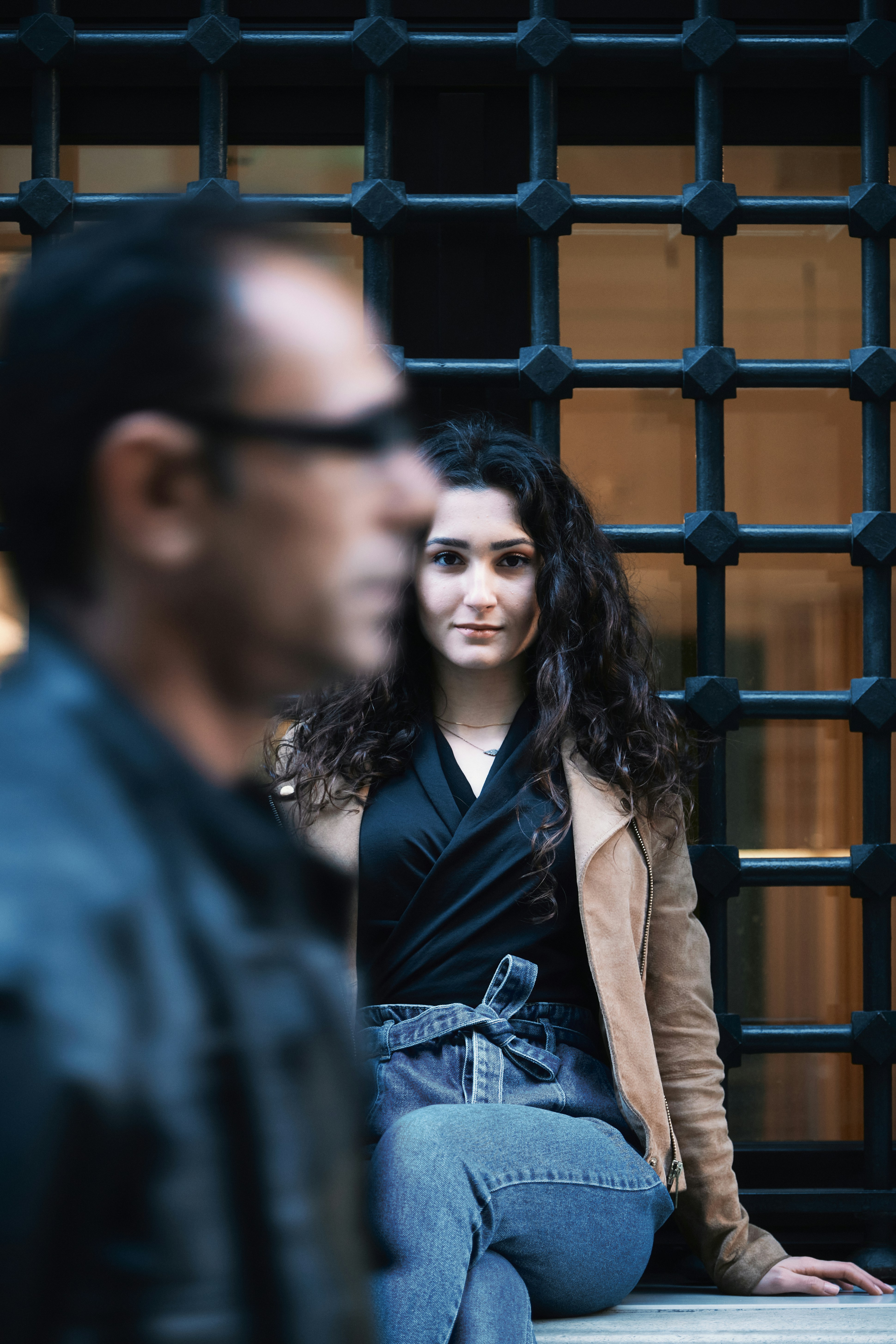 검은 가죽 재킷을 입은 여자가 파란 셔츠를 입은 남자 옆에 서 있다