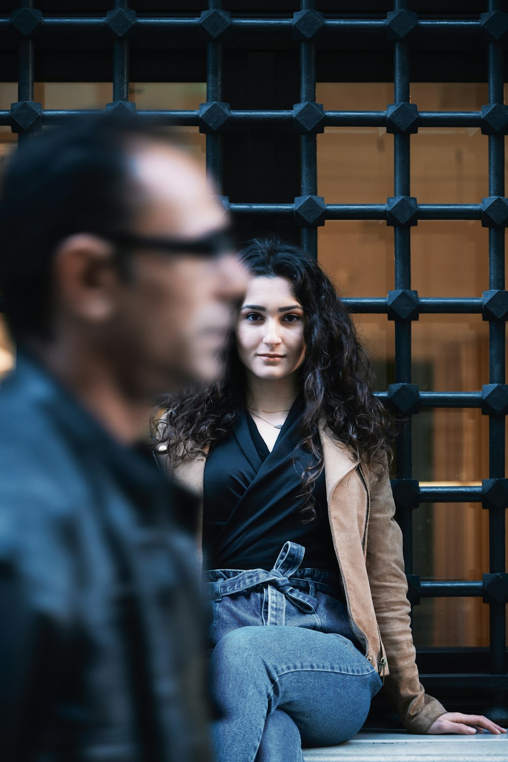 woman in black leather jacket standing beside man in blue shirt