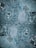 The image features a detailed close-up view of marble or stone tiles with intricate swirling patterns in shades of blue and gray. The tiles are arranged in a symmetrical pattern, creating a visually pleasing and consistent design.
