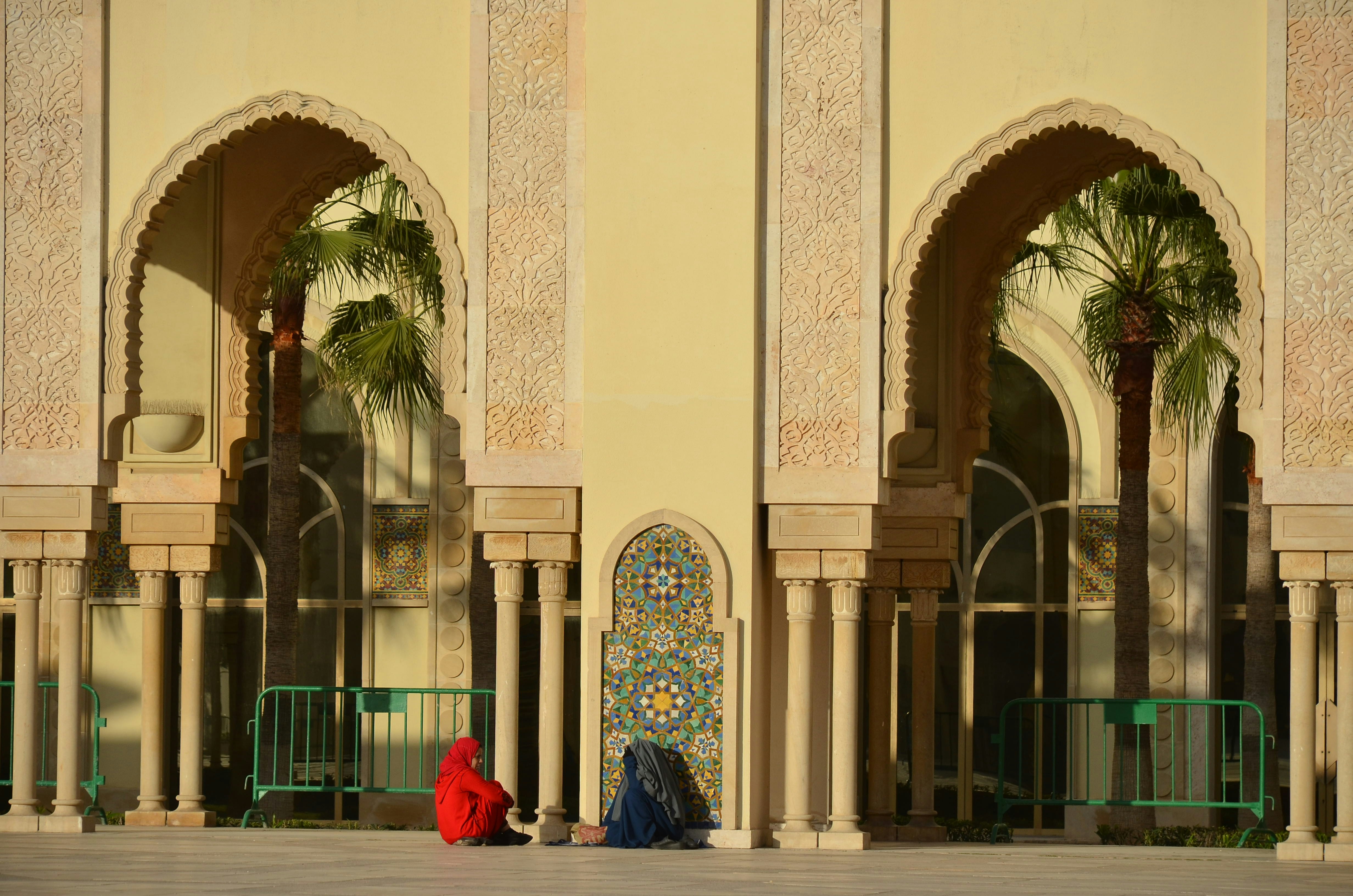 woman in black dress standing near beige concrete building during daytime
