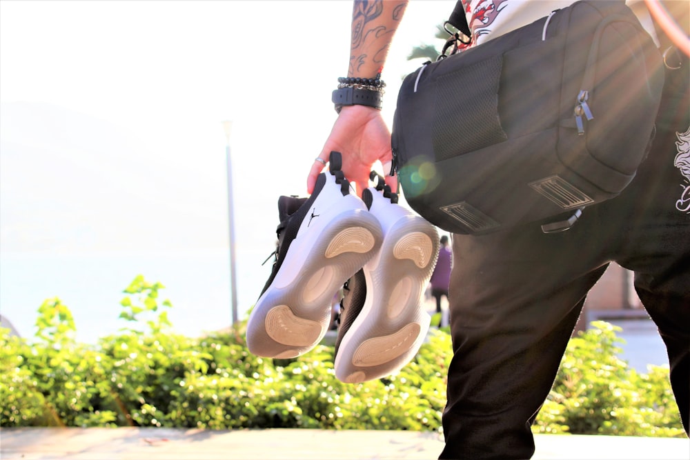 person in black pants and white shoes