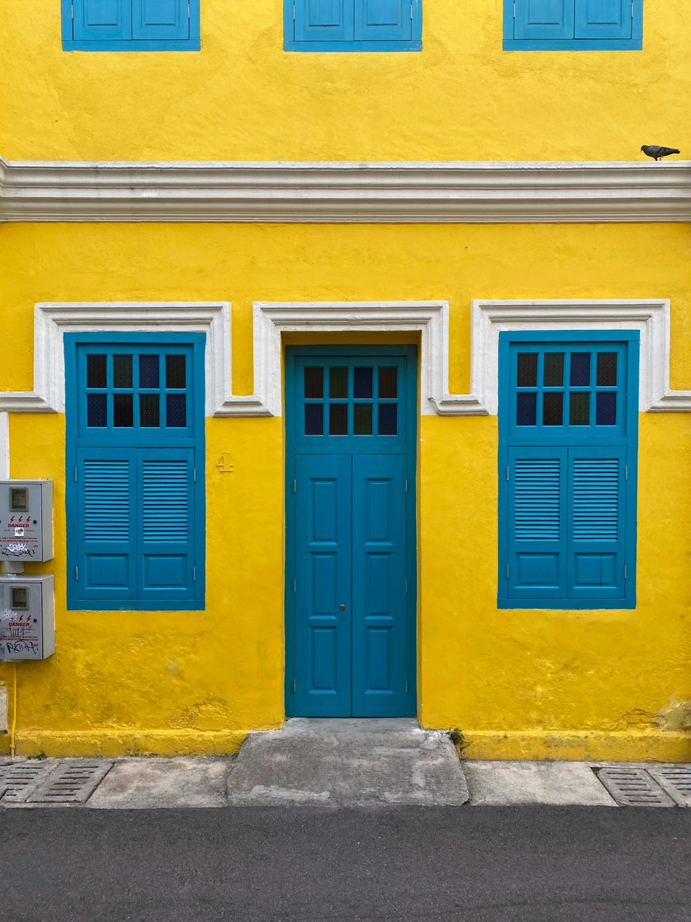 노란 콘크리트 건물에 파란 나무로 되는 문