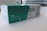 A box containing a COVID-19 antigen test kit, labeled 'Précisio Test', is placed on a white surface. The box is primarily green and white, with text in both English and Arabic. The image shows the product design and branding details.
