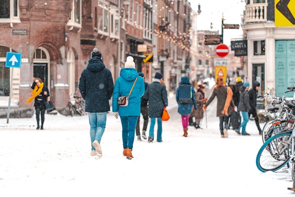 people walking on snow covered road during daytime