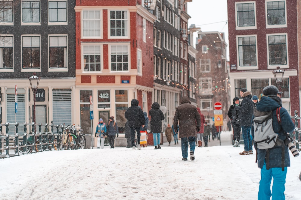 people walking on snow covered road near brown concrete building during daytime