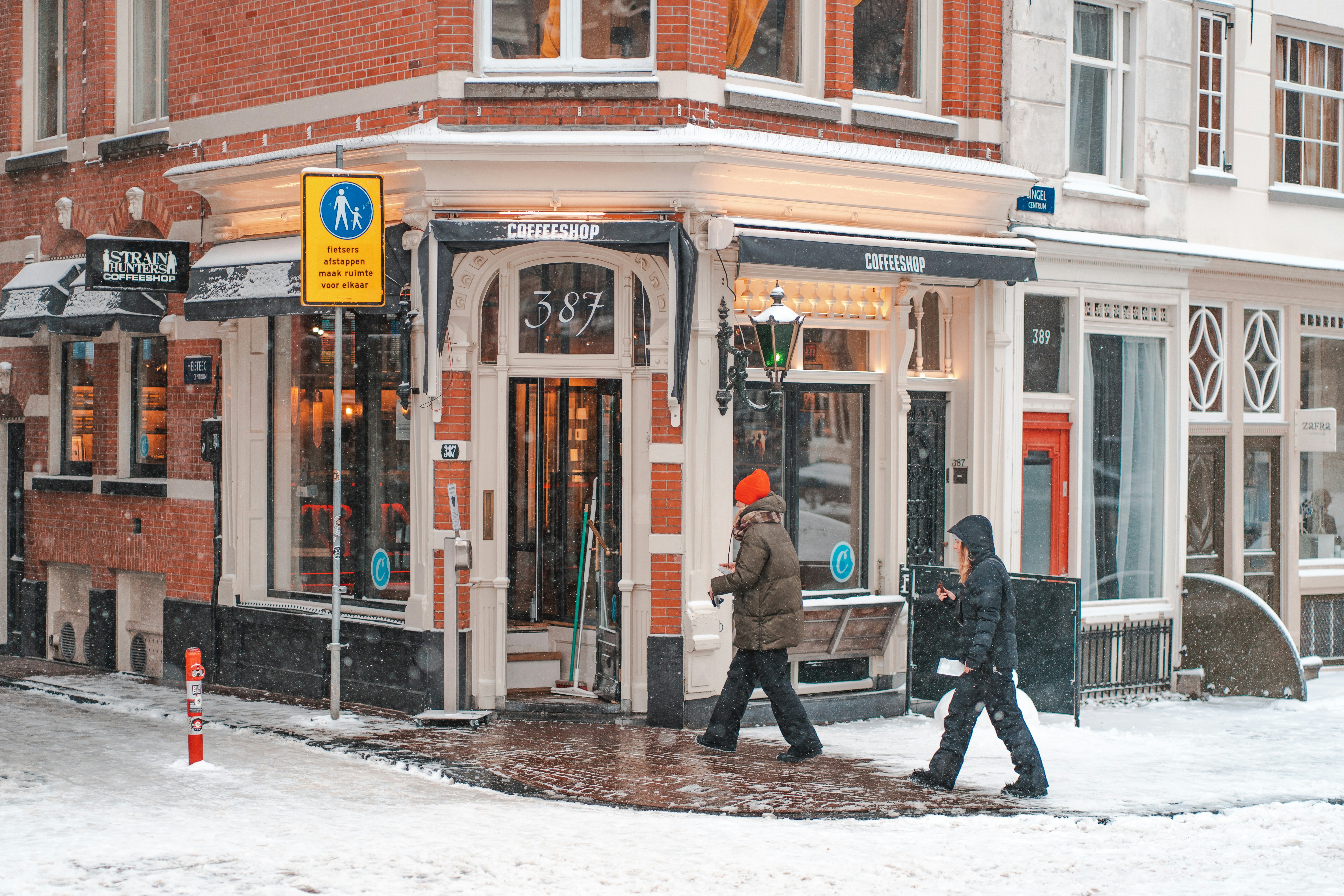 person in black jacket walking on sidewalk during daytime