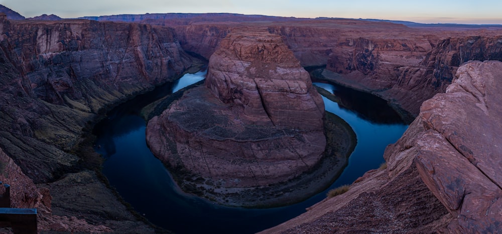 brown rock formation on blue lake during daytime