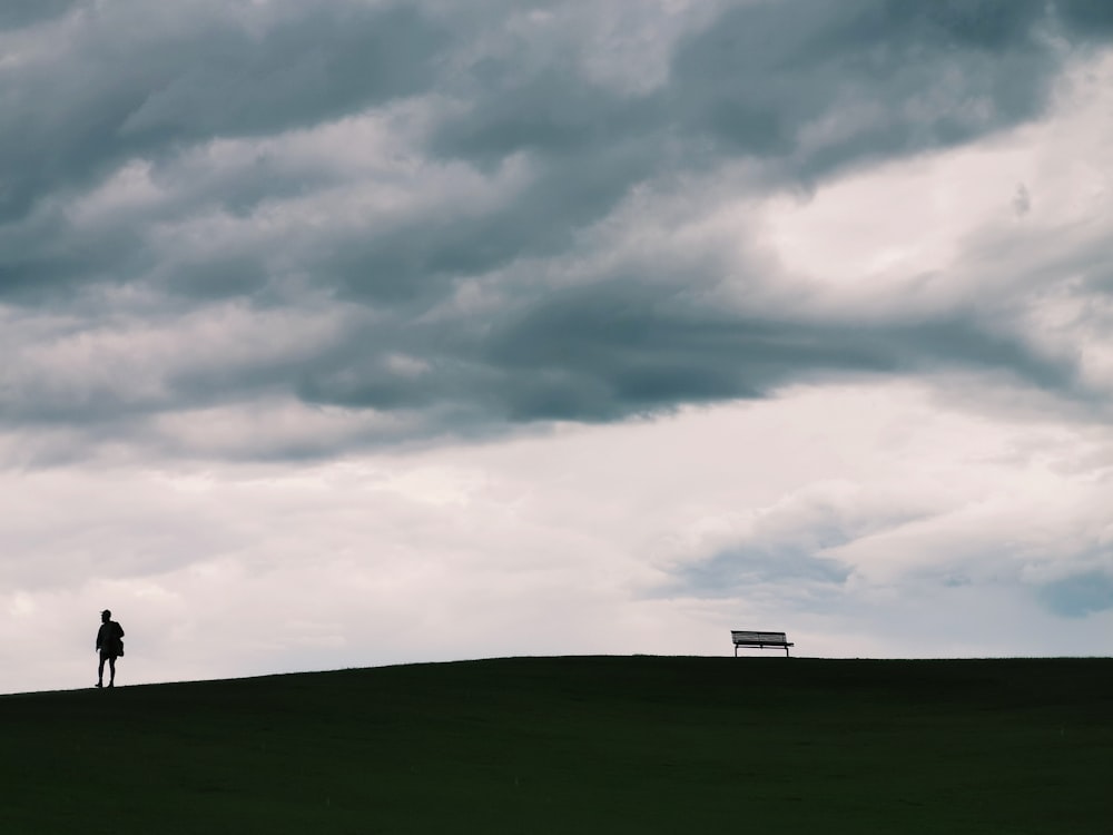 green grass field under cloudy sky during daytime