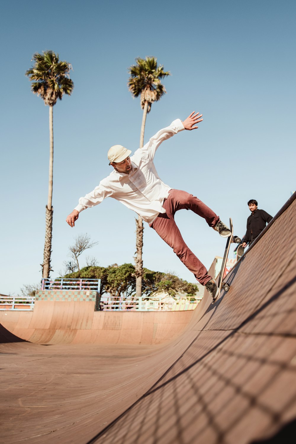 man in white shirt and brown pants riding skateboard during daytime