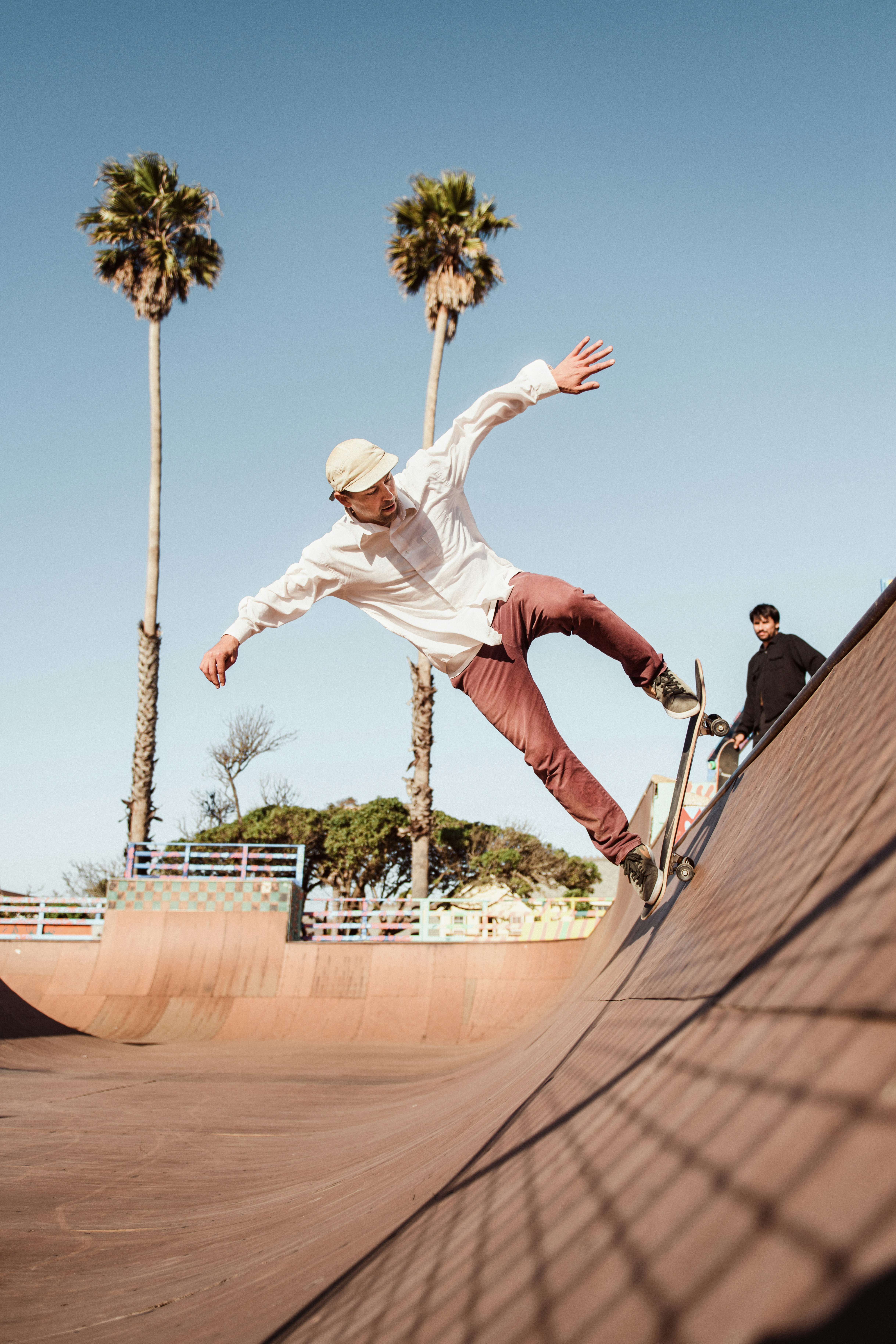 man in white shirt and brown pants riding skateboard during daytime