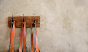 An inviting scene with vintage-style restraints hanging on an ornate wooden rack.
