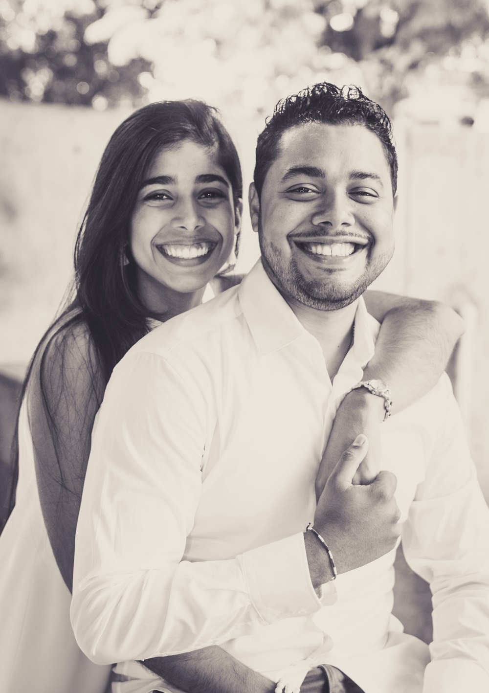 man in white dress shirt smiling beside woman in gray scarf