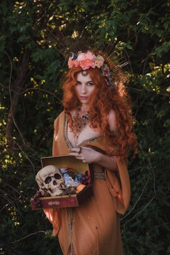 red haired witch with skull and box of herbs and spellwork