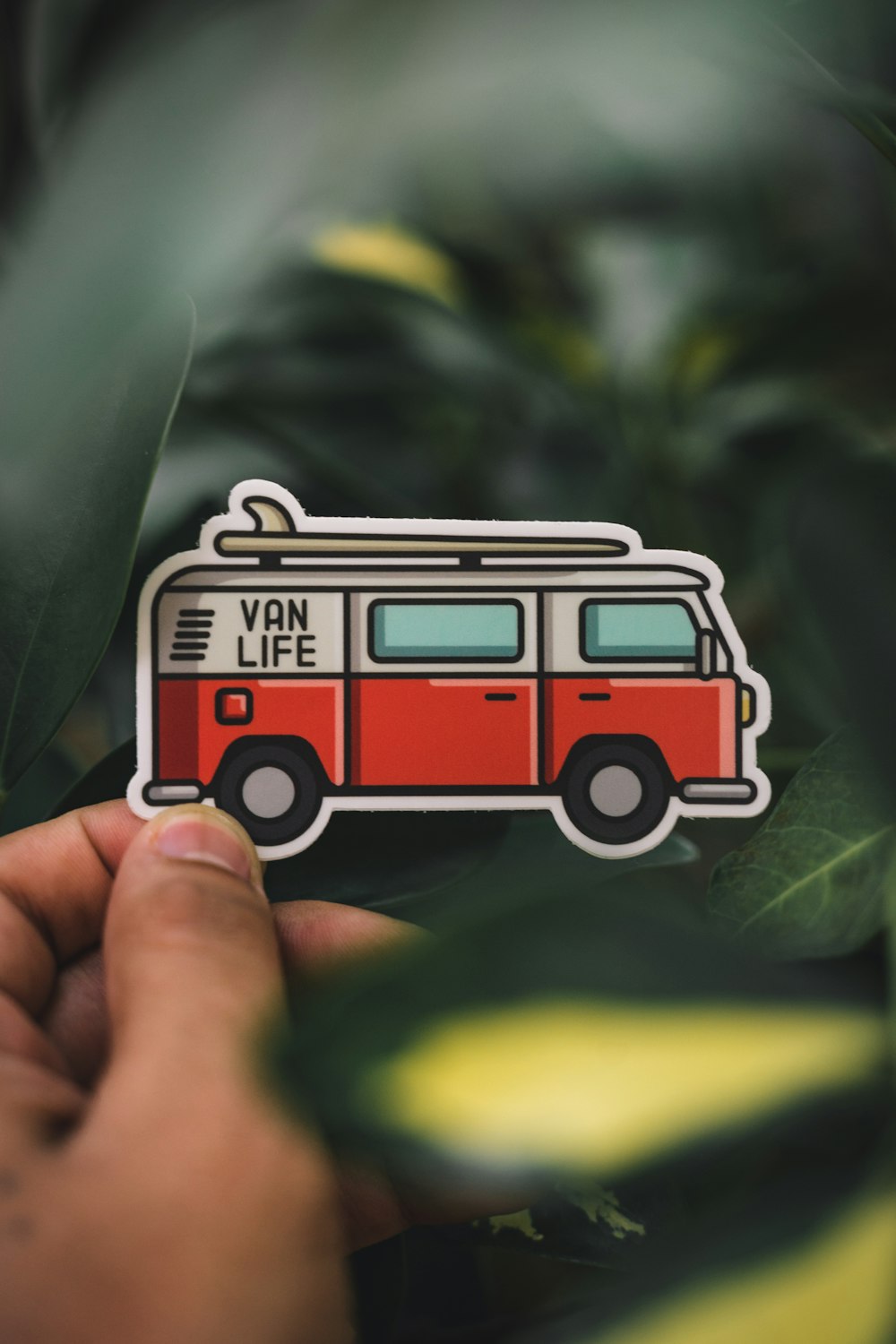 person holding red and white toy car