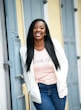 woman in white long sleeve shirt and blue denim jeans standing beside white wooden door during