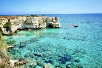 brown rock formation on blue sea during daytime