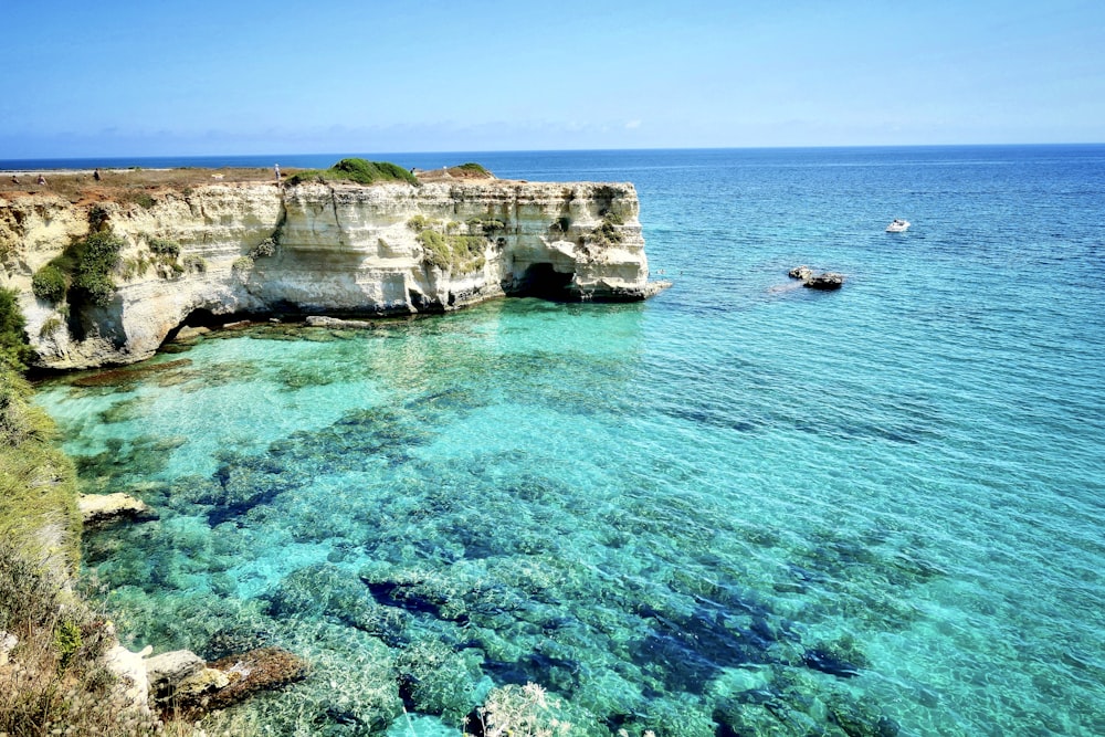 昼間の青い海に浮かぶ茶色の岩層