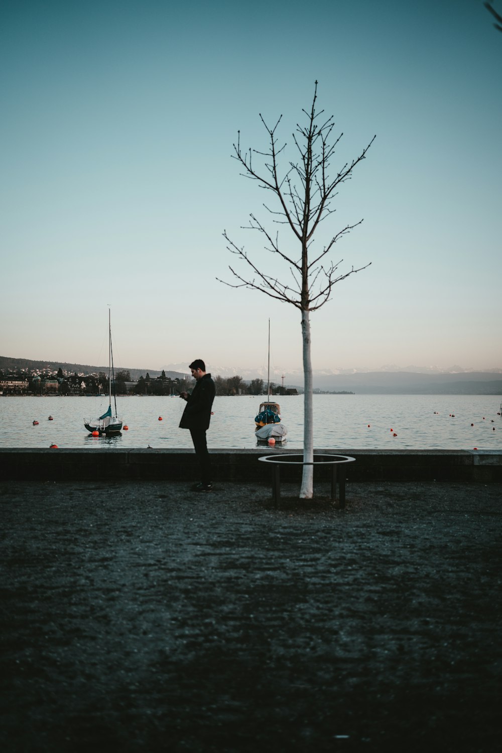 couple standing on dock near body of water during daytime