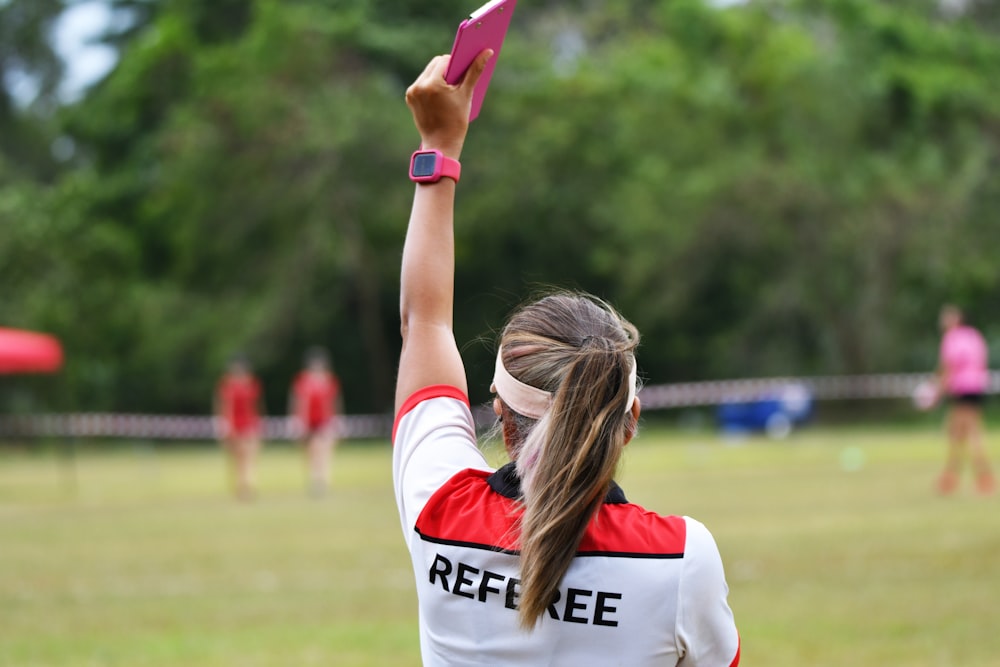 woman in white and blue shirt holding pink and white plastic tube