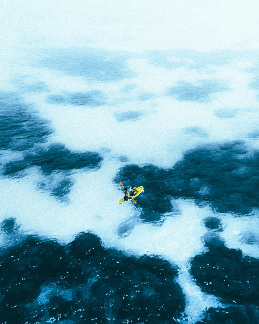 person in yellow and black wetsuit surfing on blue ocean water during daytime