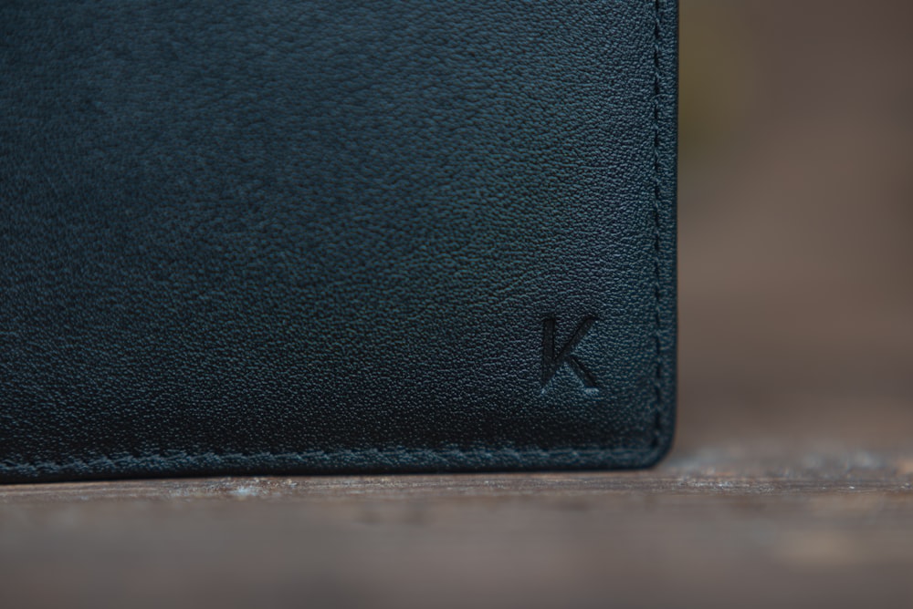 black leather bifold wallet on white table