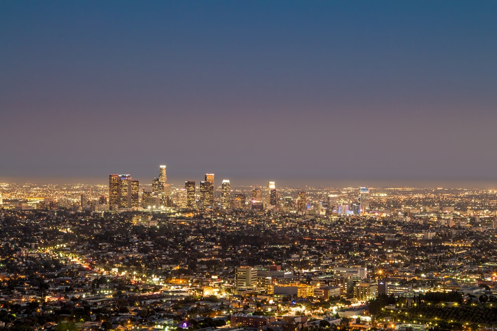 city skyline under blue sky during night time