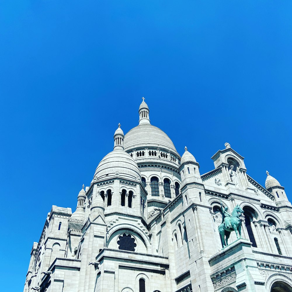 Edificio de hormigón blanco bajo el cielo azul durante el día