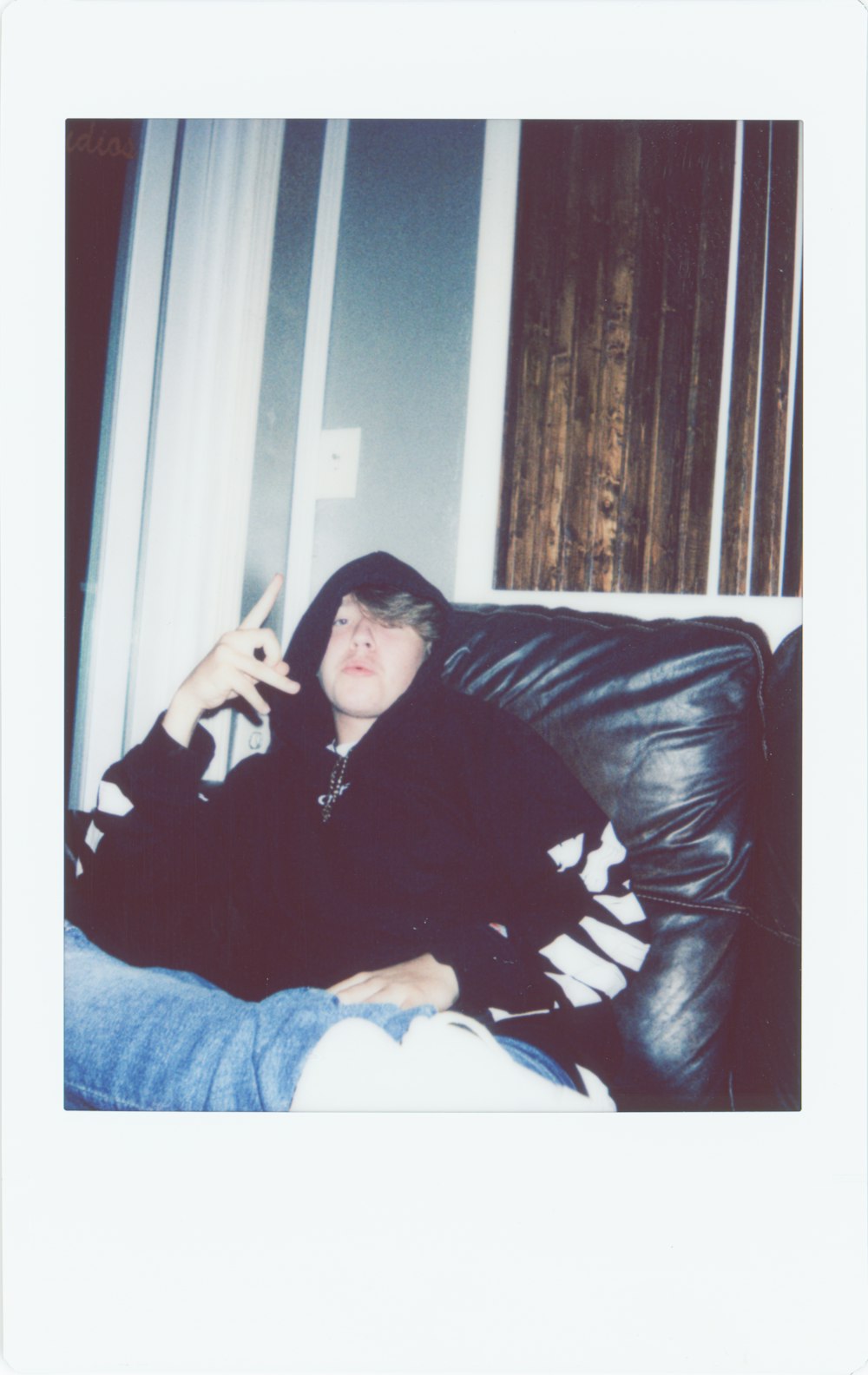 woman in black jacket and blue denim jeans sitting on black leather couch