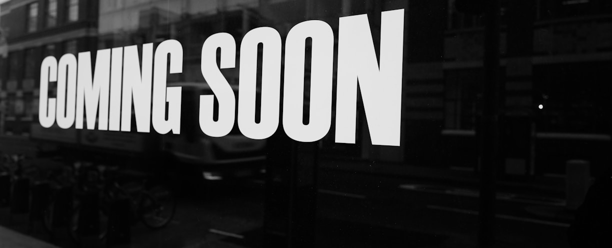 a black and white photo of a sign that says coming soon