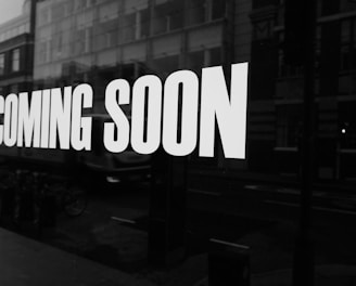 a black and white photo of a sign that says coming soon