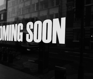 a black and white photo of a sign that says coming soon