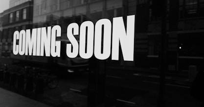 a black and white photo of a sign that says coming soon