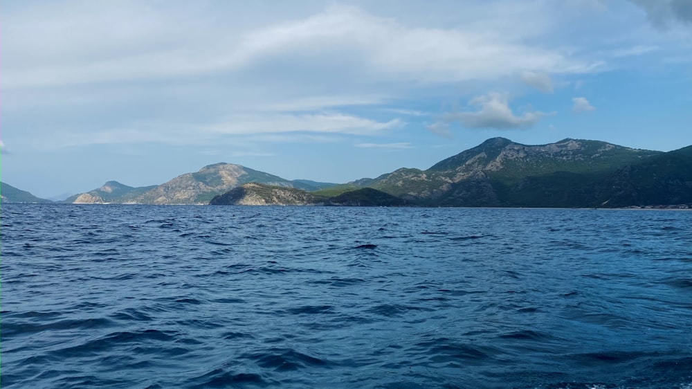 body of water near mountain during daytime