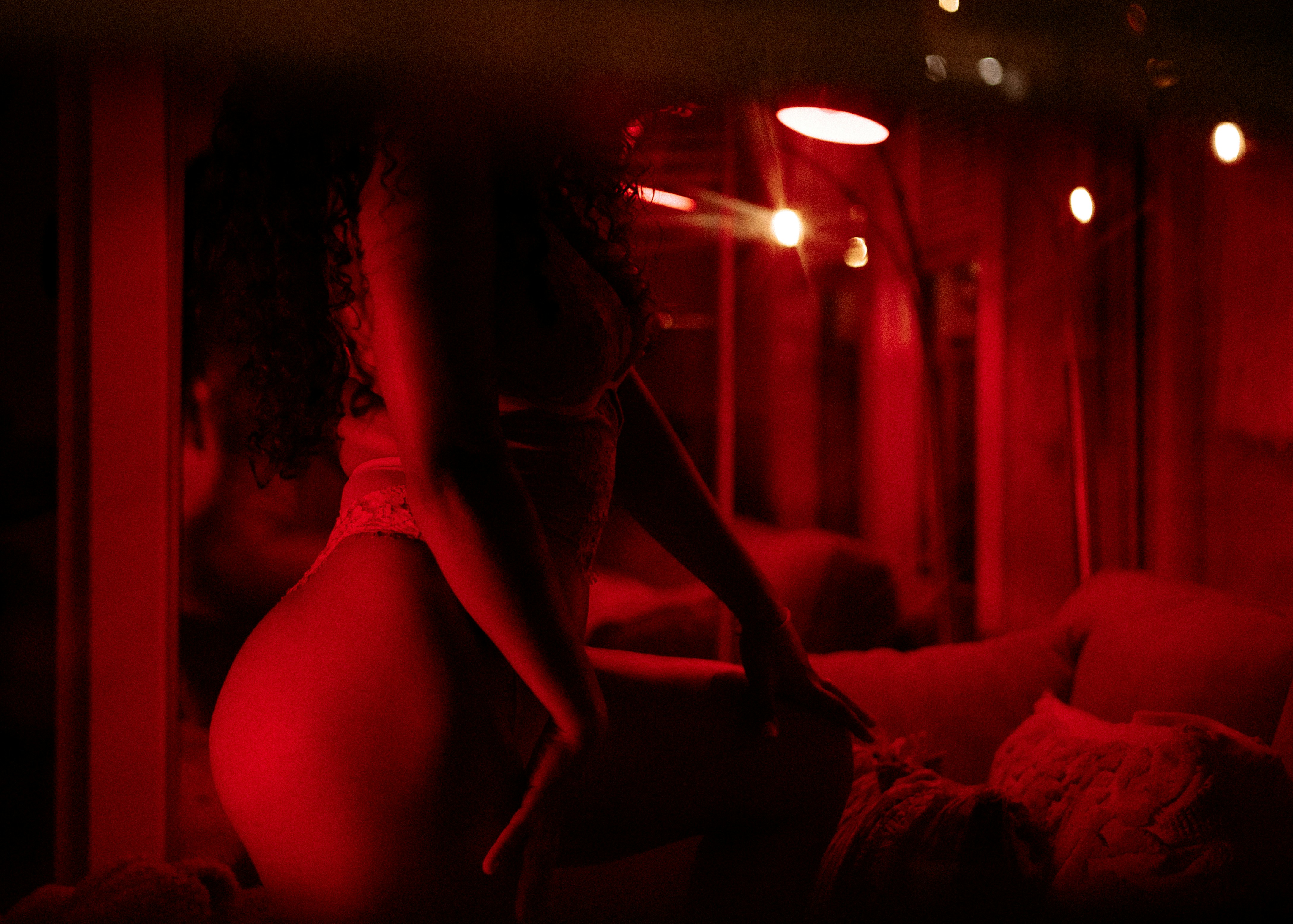 woman in white brassiere sitting on bed