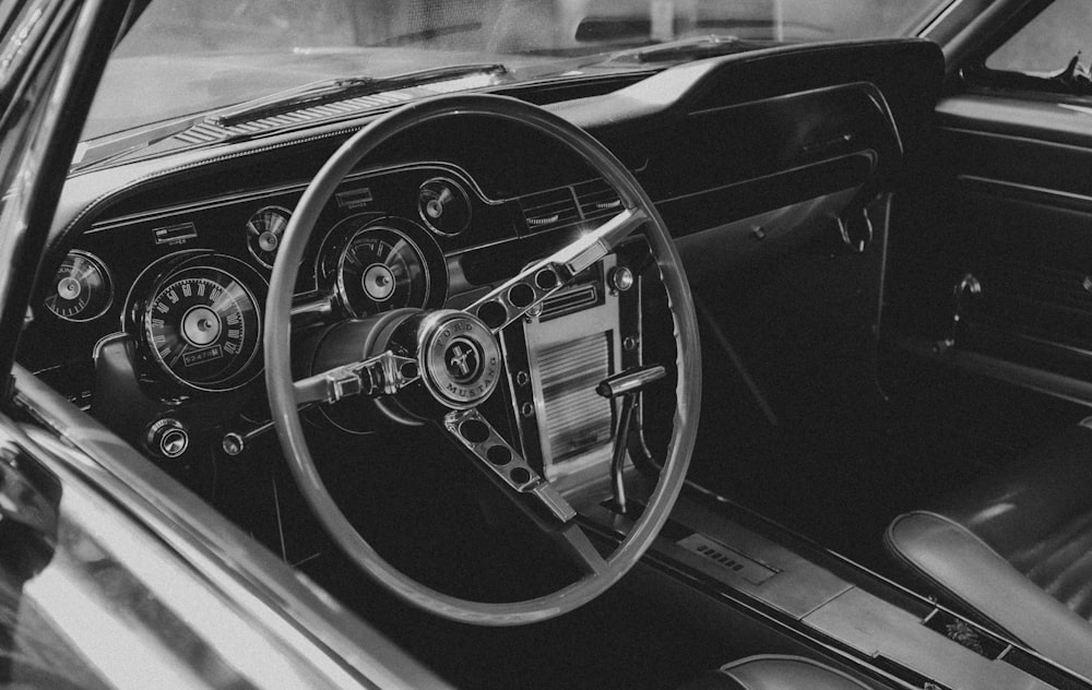 grayscale photo of car steering wheel