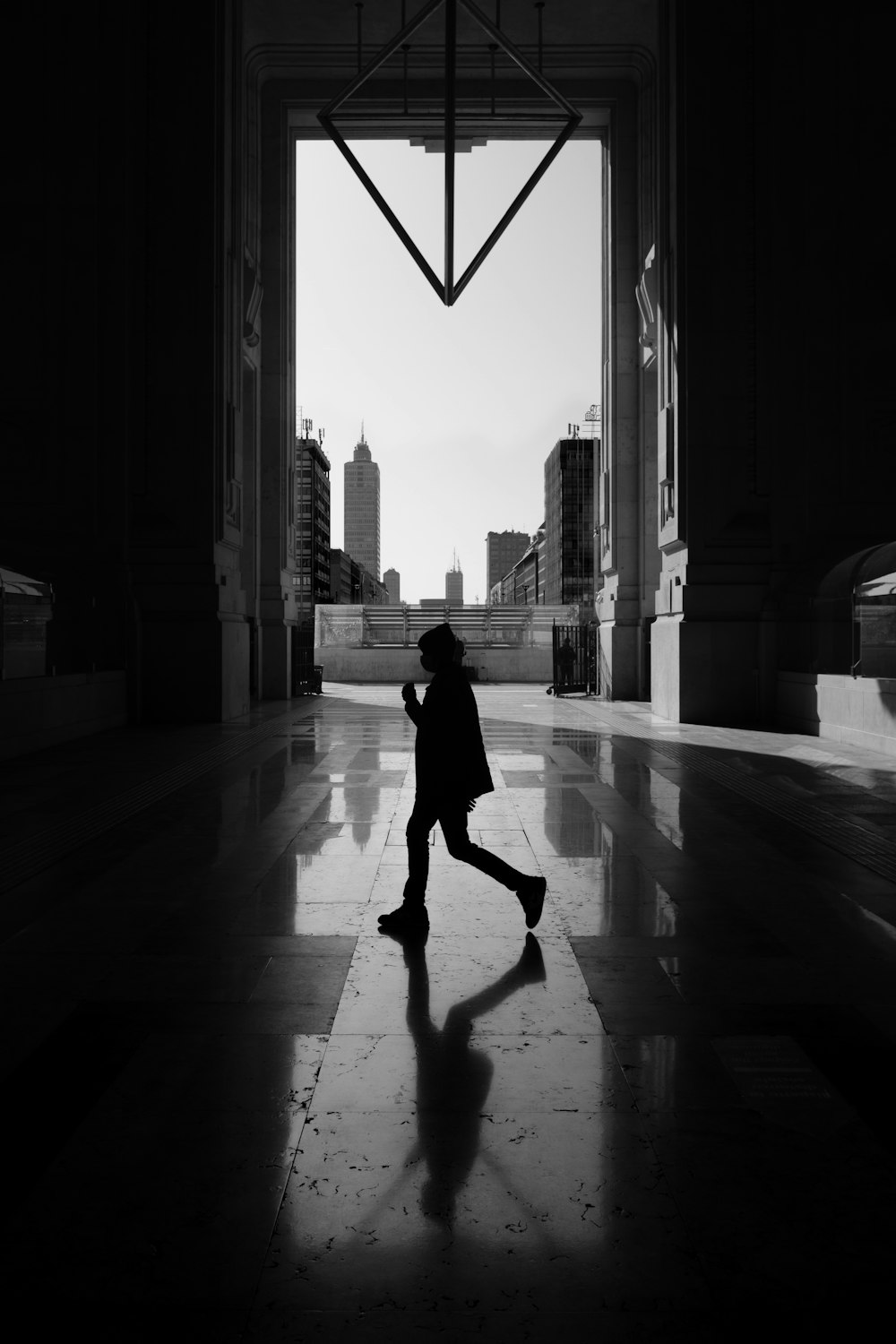 foto in scala di grigi di donna che cammina sul marciapiede