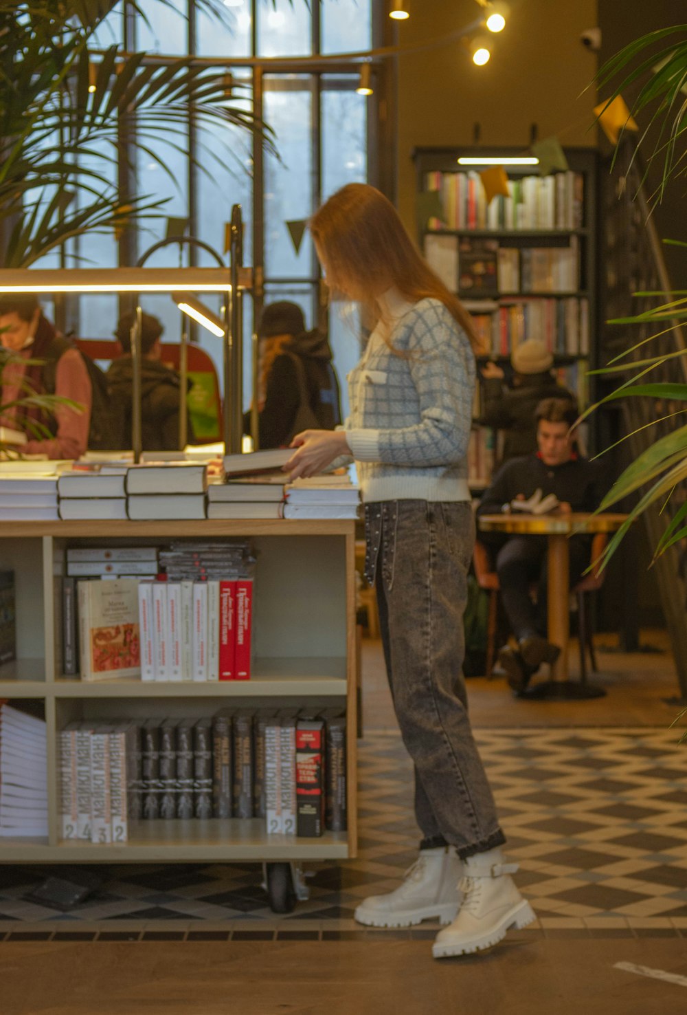 woman in gray long sleeve shirt standing in front of counter