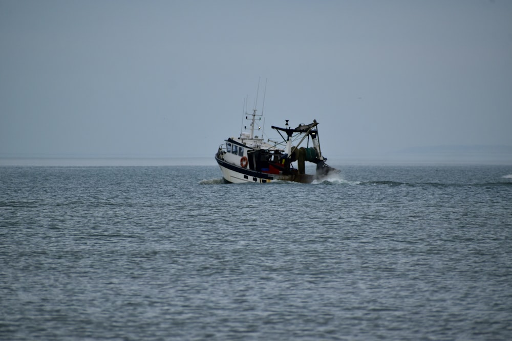 white and black boat on sea during daytime