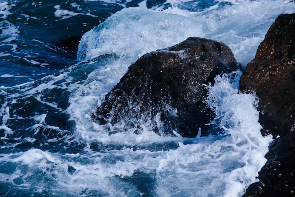 brown rock formation on body of water during daytime