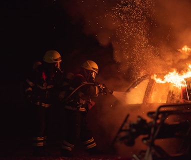 2 men in black helmet standing near fire