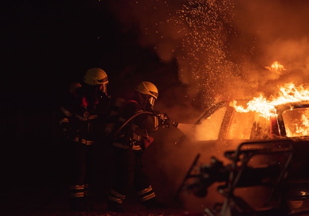 2 men in black helmet standing near fire