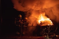 Firefighters extinguishing a vehicle fire on a highway.