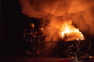 Firefighters extinguishing a vehicle fire on a highway.