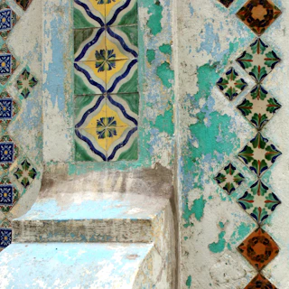 Close-up of intricate Peranakan tile patterns on a heritage building wall.