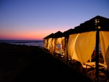 A cozy beachside cabana bathed in warm orange sunset light.