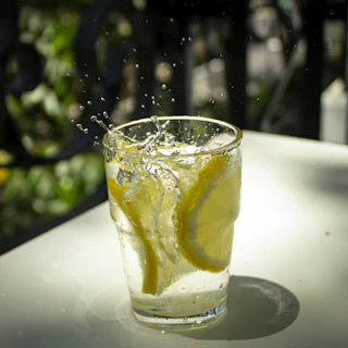 Close-up of a clear glass filled with sparkling Indian mineral water against a sunlit background.