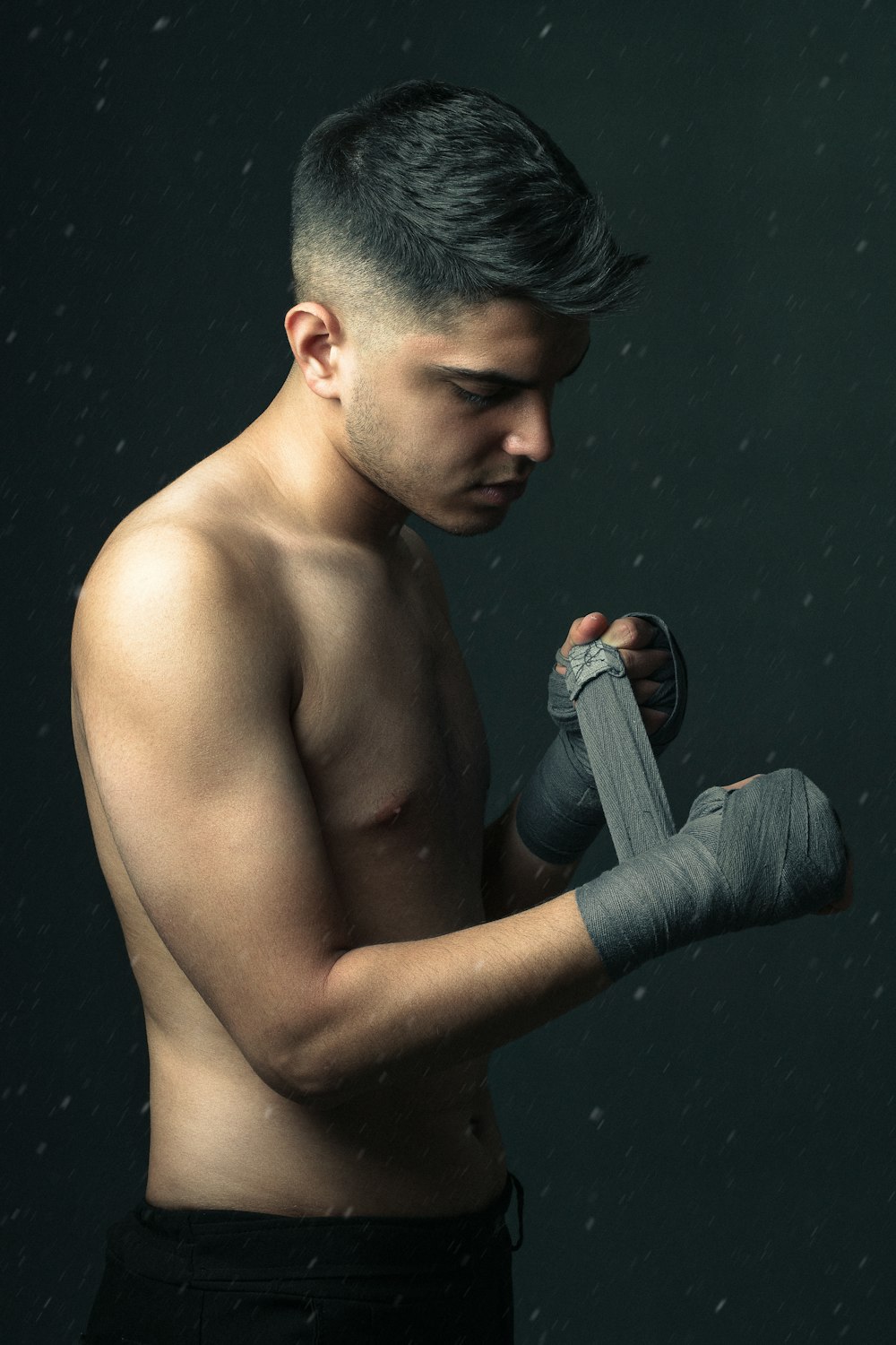 topless man holding gray and black bottle